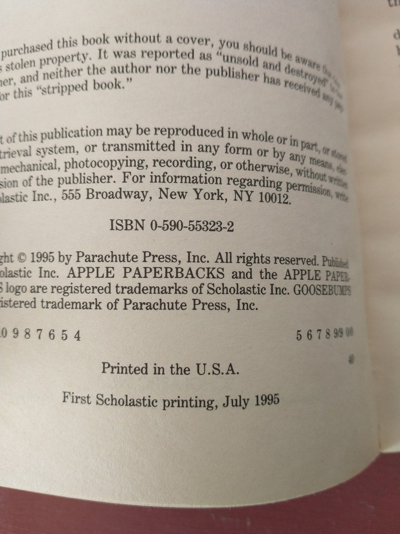 May include: A close-up of the copyright and publishing information for a book. The text reads "Copyright 1995 by Parachute Press, Inc. All rights reserved. Published by Scholastic Inc. APPLE PAPERBACKS and the APPLE PAPER logo are registered trademarks of Scholastic Inc. GOOSEBUMPS registered trademark of Parachute Press, Inc. ISBN 0-590-55323-2 Printed in the U.S.A. First Scholastic printing, July 1995."