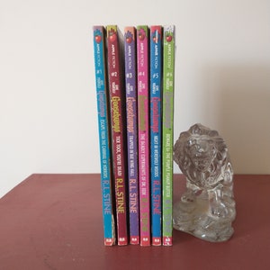 May include: A set of six Goosebumps books by R.L. Stine, featuring colorful covers with spooky illustrations. The books are arranged in order from #1 to #6, with titles like "Escape from the Carnival of Horrors" and "Night in Werewolf Woods".