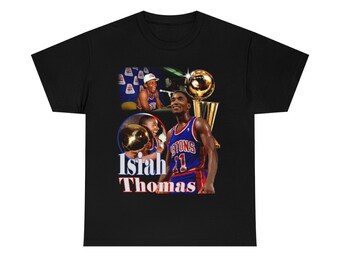 May include: Black t-shirt with a vintage-style graphic of Isiah Thomas, a basketball player for the Detroit Pistons, holding a basketball. The graphic includes the team's logo and the text "Isiah Thomas".
