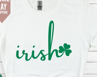 May include: White t-shirt with the word "irish" written in green cursive script with a green shamrock next to it.
