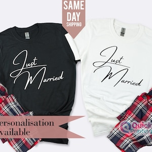 Peut inclure: Deux t-shirts noirs et blancs avec le texte "Just Married" en écriture cursive. Les t-shirts sont associés à un pantalon de pyjama à carreaux rouge et noir. Personnalisation disponible.