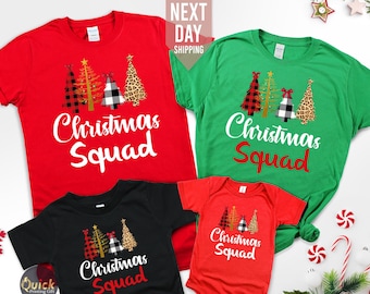May include: A set of four Christmas shirts featuring a red, green, black, and white design with three stylized Christmas trees. The shirts have the text "Christmas Squad" printed on them.