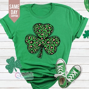 May include: Green t-shirt featuring a black and brown leopard print shamrock design.