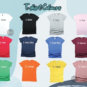 May include: A color chart titled T-shirt Colours displaying twelve short-sleeved t-shirts in various shades: white, black, grey, pink, red, navy blue, royal blue, maroon, green, orange, yellow, and mauve, each numbered and labeled accordingly.