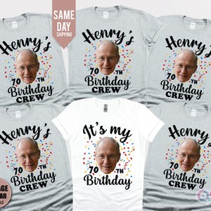 Könnte beinhalten: Eine Auswahl an grauen und weißen T-Shirts mit individuellem Geburtstagsdesign. Jedes Shirt zeigt ein Foto, den Namen "Henry's" und den Text "70th Birthday Crew". Ein Shirt trägt die Aufschrift "It's my 70th Birthday".