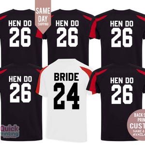 May include: Five black t-shirts with red and white accents. The shirts have the text "Hen Do" and a number printed on the back. One white t-shirt has the text "Bride" and a number printed on the back. The shirts are available with custom name and year.