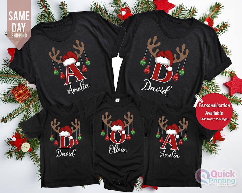 May include: Black Christmas family t-shirts with reindeer antlers, Santa hats, and personalized initials and names. The shirts feature red and green ornaments. The text "Personalisation Available" is visible.