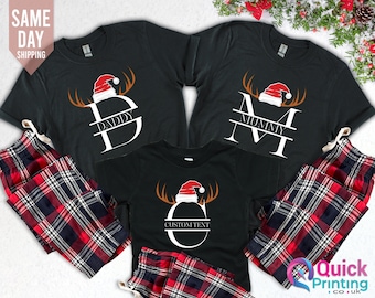 Könnte beinhalten: Schwarze Weihnachtspyjamas mit rot-schwarzen karierten Hosen. Die Shirts zeigen einen weißen Buchstaben mit einem Rentiergeweih und einem Weihnachtsmann-Hut-Design. Die Shirts sind mit dem Text "Daddy", "Mummy" und "Custom Text" personalisiert.