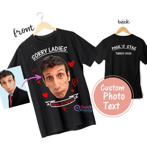 May include: Black t-shirt with a white graphic that says "Sorry Ladies" and a photo of a man's face with the text "Paul is Taken" underneath. The back of the shirt has the text "Paul's Stag Turkey 2025".