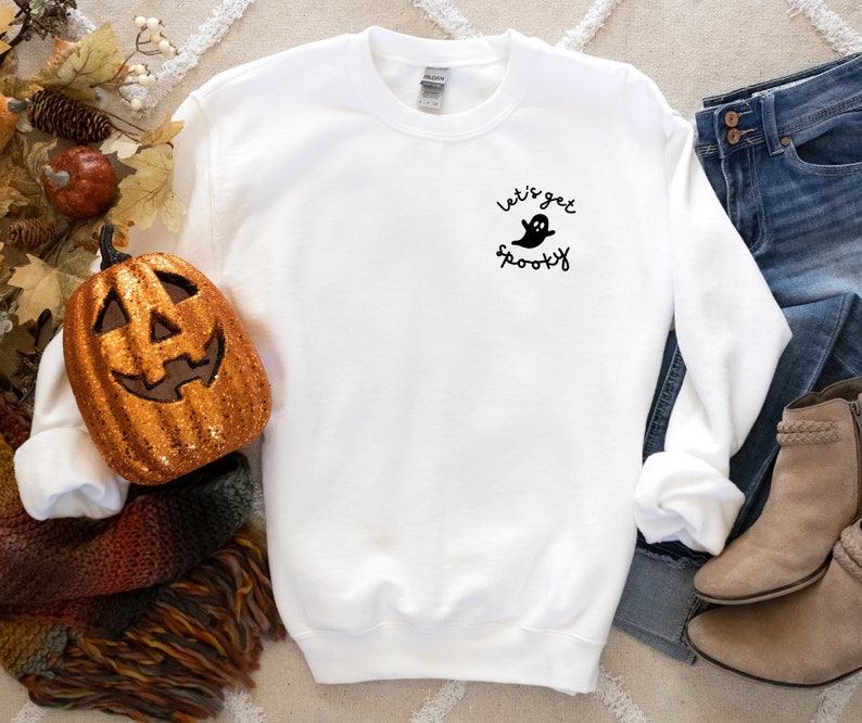 May include: White sweatshirt with a black ghost graphic and the text "Let's get spooky".
