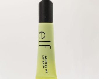 May include: A yellow and black tube of lip balm with a keychain attached. The tube is labeled "elf" and "Squeeze Me Lip Balm".