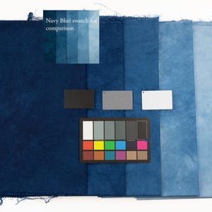 K&ouml;nnte beinhalten: Eine Sammlung rechteckiger Stoffmuster, die in einem Farbverlauf von Dunkelmarineblau bis Hellhimmelblau angeordnet sind. Das Bild enth&auml;lt eine Farbreferenzkarte, drei kleine rechteckige Karten in Schwarz, Grau und Wei&szlig; sowie den Text Navy Blue swatch for comparison.