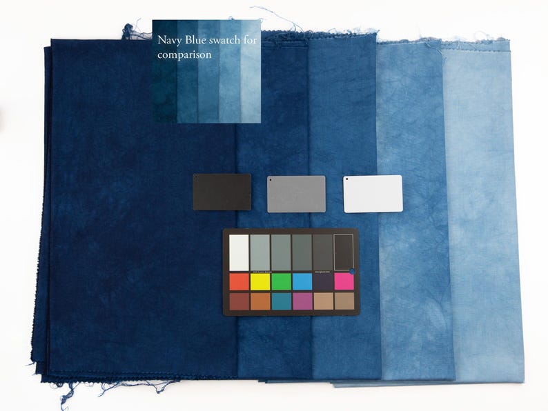 K&ouml;nnte beinhalten: Eine Sammlung rechteckiger Stoffmuster, die in einem Farbverlauf von Dunkelmarineblau bis Hellhimmelblau angeordnet sind. Das Bild enth&auml;lt eine Farbreferenzkarte, drei kleine rechteckige Karten in Schwarz, Grau und Wei&szlig; sowie den Text Navy Blue swatch for comparison.