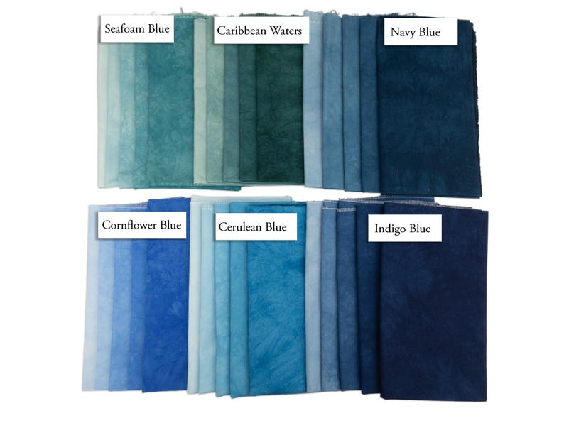 K&ouml;nnte beinhalten: Eine Sammlung von Stoffmustern in zwei Reihen, die verschiedene Blau- und T&uuml;rkist&ouml;ne zeigen. Die Beschriftungen umfassen Seafoam Blue, Caribbean Waters, Navy Blue, Cornflower Blue, Cerulean Blue und Indigo Blue. Jedes St&uuml;ck weist eine gesprenkelte, texturierte Optik mit unterschiedlicher Farbintensit&auml;t auf.