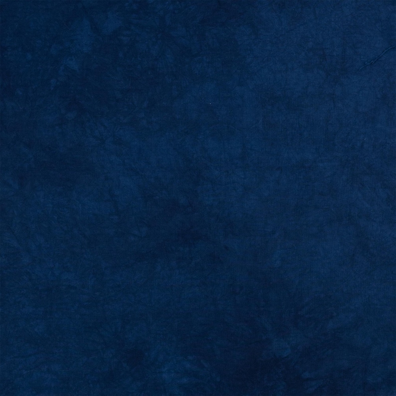 K&ouml;nnte beinhalten: Ein einfarbiger Stoff in tiefem Marineblau mit einer subtilen, gesprenkelten Textur. Die Oberfl&auml;che weist leichte Farbvariationen auf, die ein weiches, wolkenartiges Erscheinungsbild &uuml;ber das gesamte Material erzeugen, ohne erkennbare Muster.