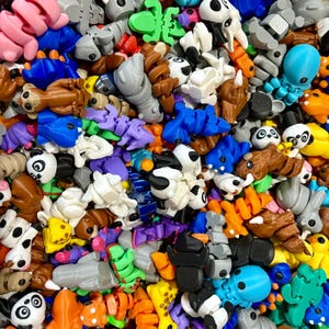 May include: A large collection of colorful, small, plastic figurines. The figurines are in the shape of animals, insects, and other creatures. They are all different colors and have a variety of textures.