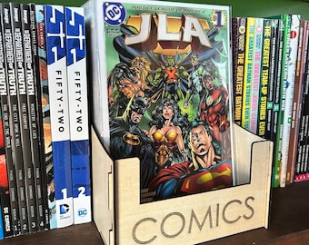 以下が含まれることがあります： 「COMICS」と刻まれた木製のコミックオーガナイザー。オーガナイザーには、ジャスティスリーグ・オブ・アメリカが表紙のコミックが入っており、スーパーマン、バットマン、グリーンランタンが大きく描かれている。