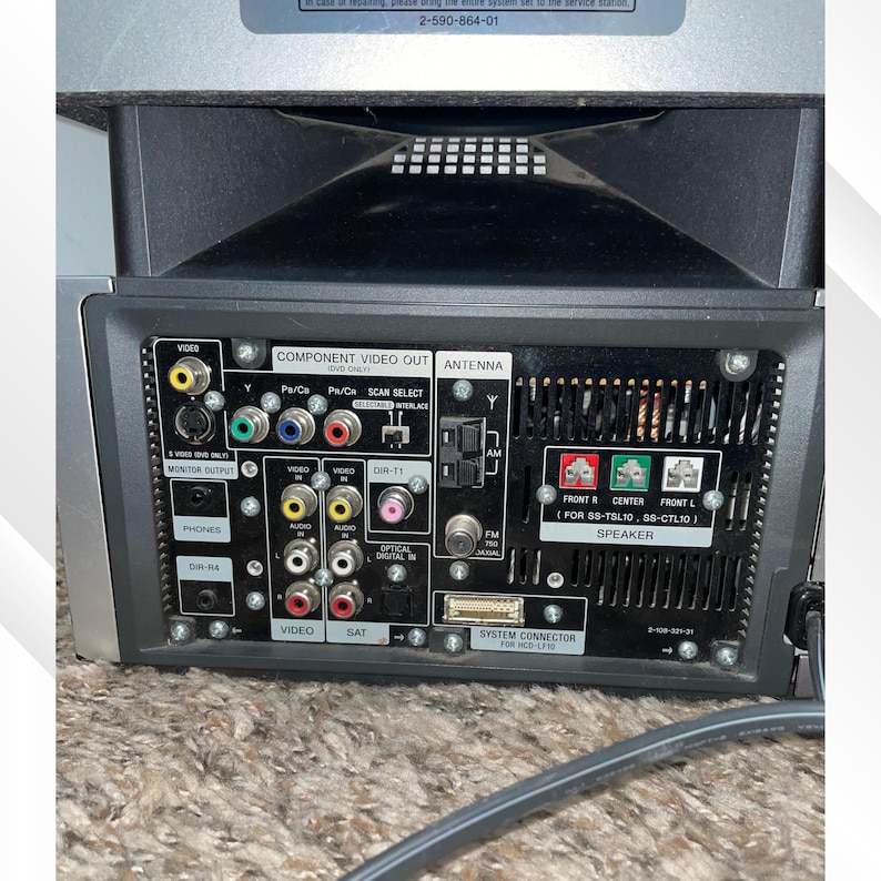 May include: A silver and black audio/video receiver with multiple input and output ports. Features include component video out, antenna, and speaker connections. The back panel has various jacks for video, audio, and digital inputs.