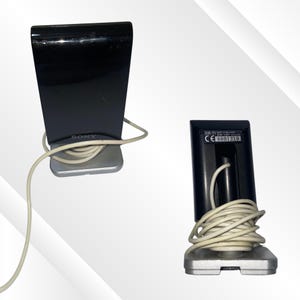 May include: Two black Sony DIR-T1 speakers with silver bases and white cords. The speakers have a glossy finish and a rectangular shape. One speaker shows the Sony logo, and the other shows the model number and serial number.
