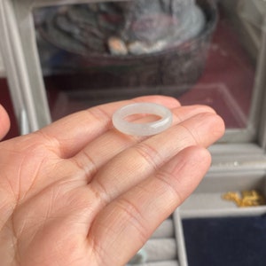 May include: A white jade ring with a smooth, polished finish. The ring is simple and elegant, and would make a beautiful addition to any jewelry collection.