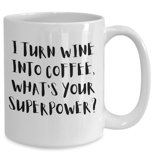 Könnte beinhalten: Weiße Keramik-Kaffeetasse mit schwarzem Text, der lautet: "Ich verwandele Wein in Kaffee, was ist deine Superkraft?"