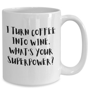Könnte beinhalten: Weiße Keramik-Kaffeetasse mit schwarzem Text, der lautet: "Ich verwandele Kaffee in Wein. Was ist deine Superkraft?"