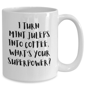 Könnte beinhalten: Weiße Keramik-Kaffeetasse mit schwarzem Text, der lautet: "Ich verwandele Mint Juleps in Kaffee, was ist deine Superkraft?"