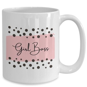Può includere: Tazza in ceramica bianca con un design rosa e nero. La tazza ha pois neri e il testo "Girl Boss" in scrittura nera su uno sfondo rosa.