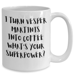 Könnte beinhalten: Weiße Keramik-Kaffeetasse mit schwarzem Text, der lautet: "Ich verwandele Vesper-Martinis in Kaffee. Was ist deine Superkraft?"