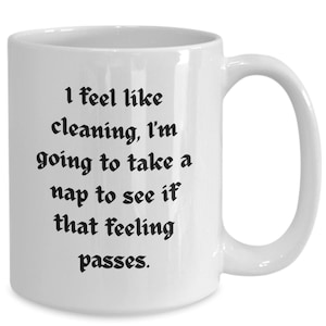 May include: White ceramic coffee mug with black text that reads "I feel like cleaning, I'm going to take a nap to see if that feeling passes."