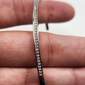 Bracelet jonc ouvert argenté Michael Kors avec strass transparents 7 po.