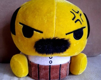 May include: Yellow plush toy with a black mustache, eyebrows, and angry eyes. The toy is wearing a white shirt and brown pants.