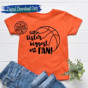 May include: Orange t-shirt with a basketball graphic and the text "little sister biggest #12 FAN!"
