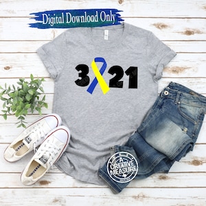 May include: A gray t-shirt with a black 321 design and a yellow and blue ribbon. The ribbon is a symbol of awareness for Down syndrome.