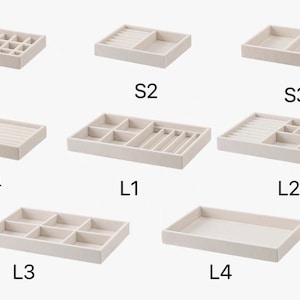 May include: A collection of eight beige velvet-lined jewelry organizer trays with various internal compartment configurations, labeled S1 through S4 and L1 through L4, designed for sorting small items like rings, earrings, and necklaces.