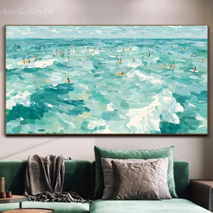 May include: An abstract painting of a turquoise ocean with numerous figures surfing. The artwork features a palette of blues and greens, with white brushstrokes depicting waves. The painting is framed and hangs above a green sofa.