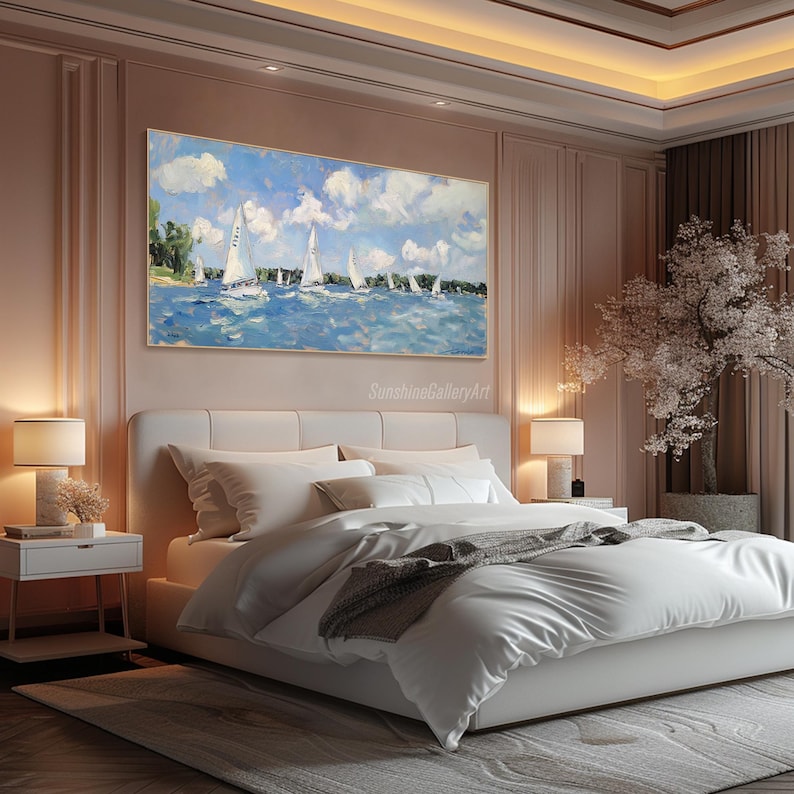 Op de afbeelding: Een schilderij van zeilboten op een blauwe watermassa met een bewolkte lucht. Het schilderij is ingelijst en hangt aan een muur in een slaapkamer met een wit bed en een wit nachtkastje.