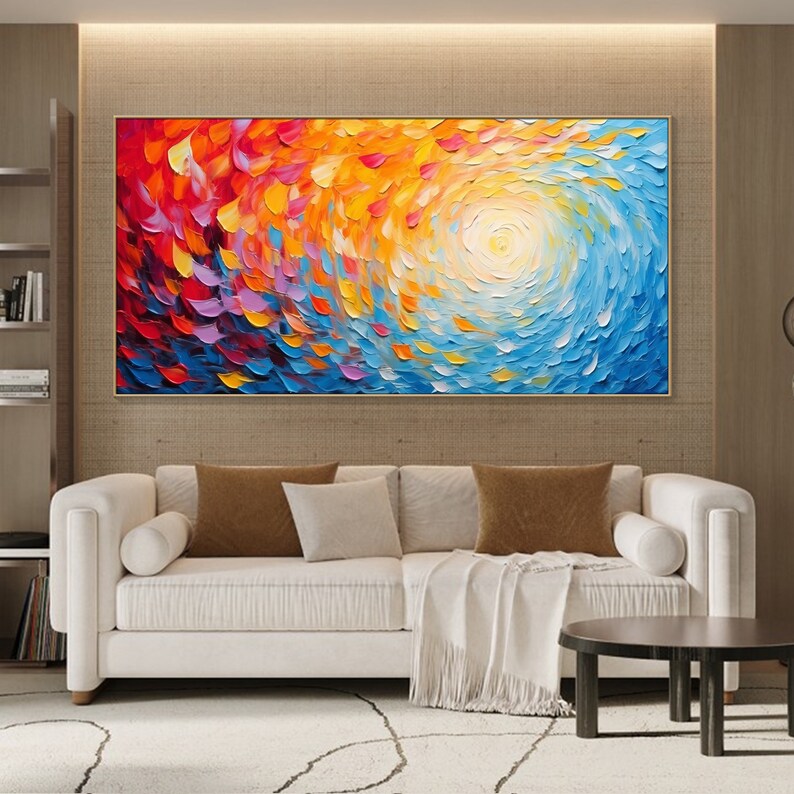 May include: Abstract painting with a swirling pattern of red, orange, yellow, blue, and purple. The painting has a white center with a sun-like shape.