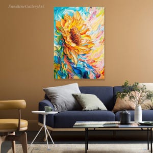 May include: A colorful abstract painting of a sunflower with blue, yellow, pink, and green hues. The sunflower is in the center of the painting and is surrounded by swirling colors.