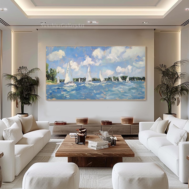 Op de afbeelding: Een schilderij van een zeezicht met witte zeilboten op een blauwe watermassa. De lucht is blauw met witte wolken. Het schilderij is ingelijst en hangt aan een muur in een woonkamer.