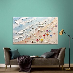 May include: A painting depicting a beach scene with colourful umbrellas and people in the water and on the sand.