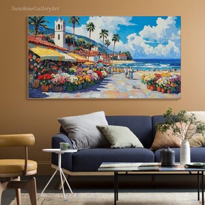 May include: A colorful painting of a seaside town with a white building, palm trees, and a flower market. The painting is in a bright, impressionistic style with bold brushstrokes.