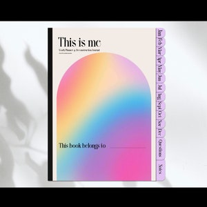 Może przedstawiać: Różowo-niebieska gradientowa okładka dziennika z tytułem "This is me" i tekstem "Year Planner & Documentation Journal". Okładka ma wzór tęczy. Dziennik ma zakładki na każdy miesiąc roku, a także zakładki na "Pytania" i "Notatki".