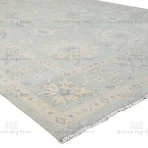 May include: A light blue rug with a floral pattern. The rug has a fringe border.