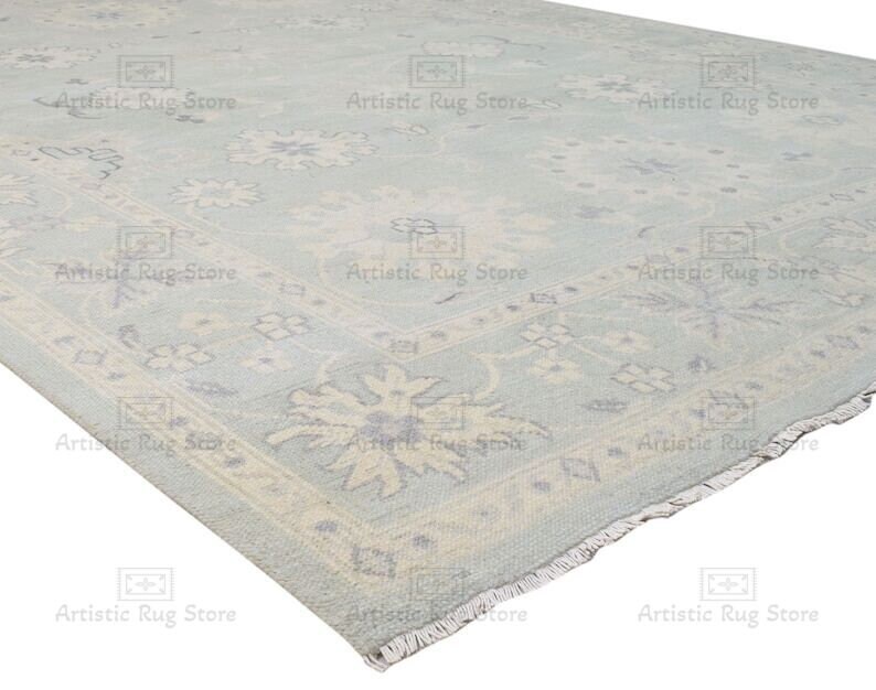 May include: A light blue rug with a floral pattern. The rug has a fringe border.