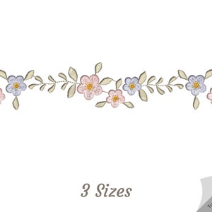 May include: A delicate floral embroidery design featuring pink and blue flowers with green leaves. The design is perfect for adding a touch of elegance to any project.  The text "3 Sizes" is included in the image.