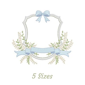 Pode incluir: Um design bordado com um laço azul claro, fita e detalhes florais. O design é emoldurado por uma borda prateada. O texto "5 Sizes" é exibido abaixo.