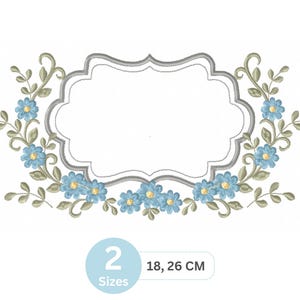 Op de afbeelding: Een geborduurd bloemmotief met een centrale, sierlijke, blanco labelvorm, omlijst door lichtblauwe bloemen en groene bladeren. Het ontwerp bevat de tekst "2 Maten" en de afmetingen 18, 26 cm.