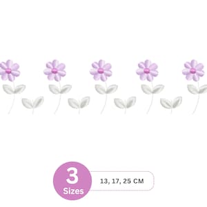 Peut inclure: Motif floral brodé avec cinq fleurs violet clair, centres roses, tiges et feuilles grises. Disponible en trois tailles : 13, 17 et 25 cm. Les fleurs sont espacées uniformément.