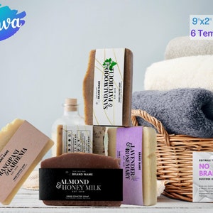 May include: Six different bars of handmade soap with various scents and labels. The soaps are arranged on a white surface with a wicker basket and towels in the background. The labels include the brand name, scent, and "Hand Crafted Soap".